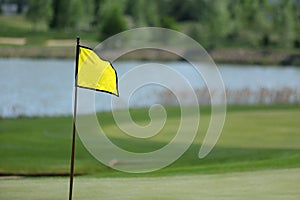 A golf course with roads, bunkers and ponds and with flag photo