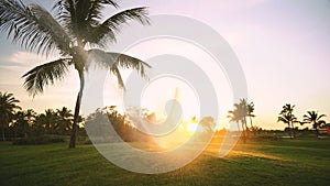 Golf course sprinkler on fairway during golden sunset