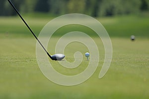 A golf driver with ball on a tee on the golf course photo