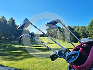 Golf equipment and clubs full of various golf clubs on green field background
