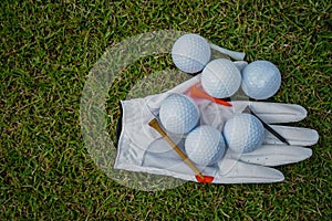 Golf equipment on green grass, ball, glove, tee and golf-club driver, golf gear and equipment on flat lay top view