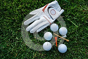 Golf equipment on green grass, ball, glove, tee and golf-club driver, golf gear and equipment on flat lay top view