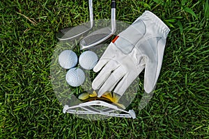 Golf equipment on green grass, ball, glove, tee and golf-club driver, golf gear and equipment on flat lay top view