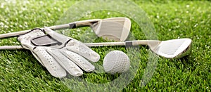 Golf equipment on green grass golf course, close up view