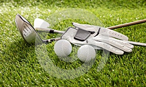 Golf equipment on green grass golf course, close up view