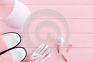 Golf equipment for ladies on a wooden surface in pink, top view