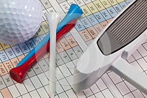 Golf equipments lying on a golf score card