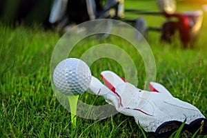 Golf glove , white golf ball on tee in a beautiful golf course