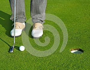 Golf green hole course man putting short ball