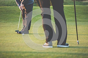 Golf green sceen - golfer putting near the hole, short putt