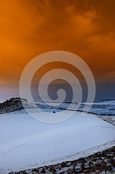 Golf green with winter orange sunset sky