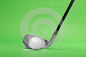 Golf Iron Club Head and Ball on a Green Background