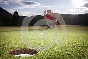 Golf player analyzing green.