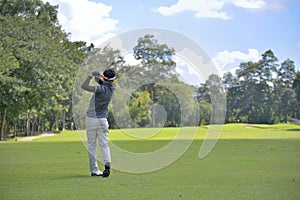 Golf player pitching the golf ball