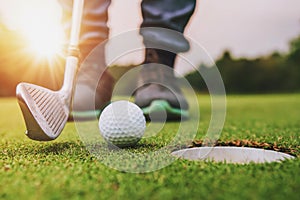 golf player putting golf ball into hole