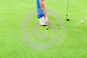 Golf player repairing divot photo