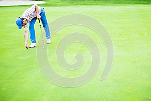 Golf player repairing divot photo