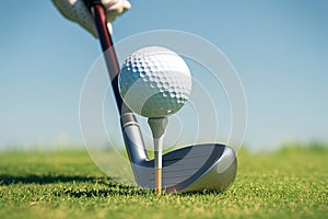 Golf player sets the ball on tee, preparing for play