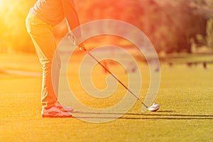 Golf player tee off at sunset