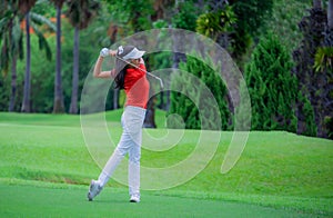 Golf player teeing off. Woman hitting golf ball from tee box with driver