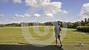 Golf player trains in a driving range completely immersed in the Tuscan countryside near Pisa, Italy