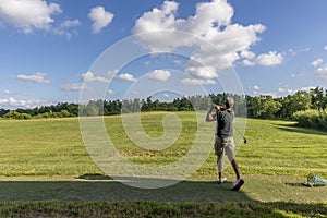 Golf player trains in a driving range completely immersed in the Tuscan countryside near Pisa, Italy