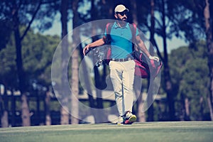 Golf player walking and carrying bag