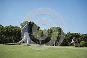 Golf player walking and carrying bag