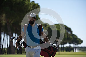 Golf player walking and carrying bag