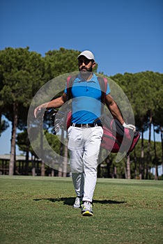 Golf player walking and carrying bag