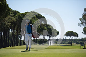 Golf player walking and carrying bag