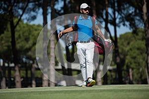 Golf player walking and carrying bag