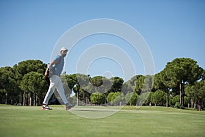 Golf player walking and carrying bag