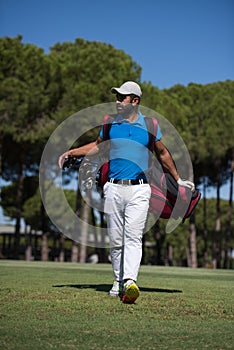 Golf player walking and carrying bag