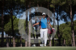 Golf player walking and carrying bag