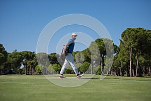 Golf player walking and carrying bag