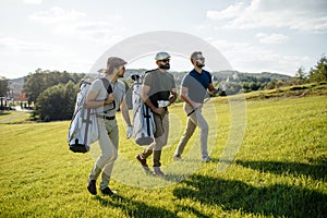 Golf player walking and carrying bag on course during summer gam