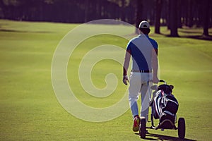 Golf player walking with wheel bag