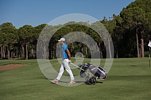 Golf player walking with wheel bag