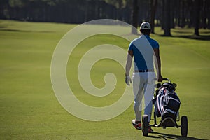 Golf player walking with wheel bag