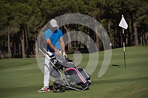 Golf player walking with wheel bag