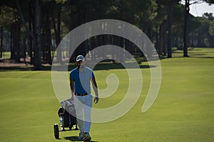 Golf player walking with wheel bag
