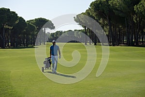 Golf player walking with wheel bag