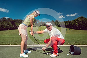 Golf pro teaching a woman student of the driving range
