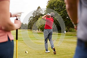 Golf Professional Demonstrating Tee Shot To Group Of Golfers During Lesson