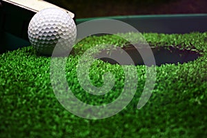 Golf and with putter on green background