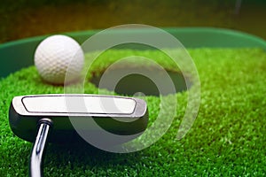 Golf and with putter on green background