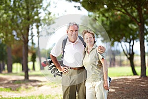 Golf - A sport that brings us closer together. Portrait of a mature and happy couple embracing during a game of golf.