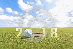 Golf sport conceptual image.Happy new year 2018. Golf ball on the green fairway