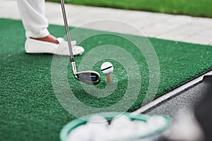 Golf stick is ready to punch the ball. Artificial grass. Human holding it